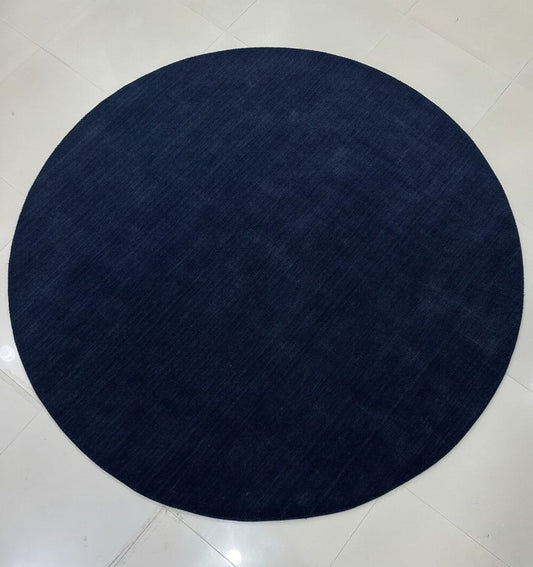 Midnight blue round hand-loom carpet made from premium New Zealand wool on tiled floor